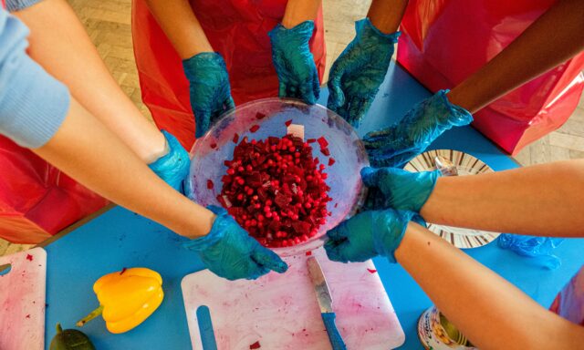 Children's hands holding bowl with beetroot